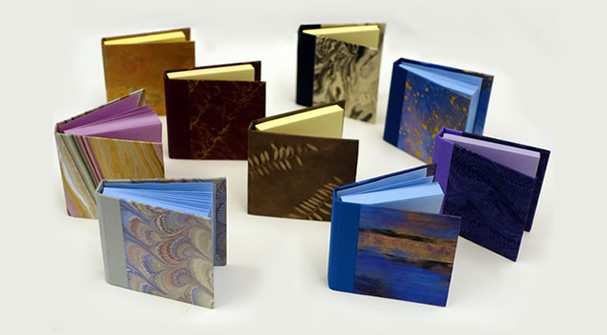Post-It Note holders in decorative book covers, group photo.
